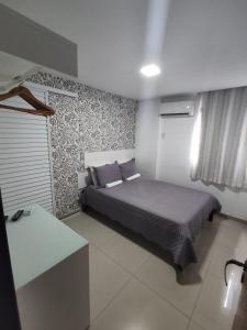 1 dormitorio con cama y pared en Apartamento Blue Tower, en Maceió