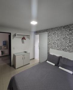 um quarto com uma cama e uma parede em Apartamento Blue Tower em Maceió