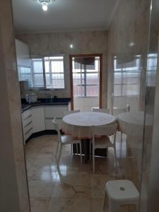 a kitchen with a table and chairs in a room at Apto Praia Grande in Praia Grande