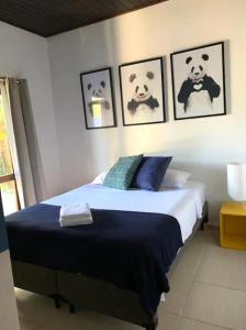 a bedroom with a bed with three teddy bears on the wall at Tropical Casa Ubatuba in Ubatuba