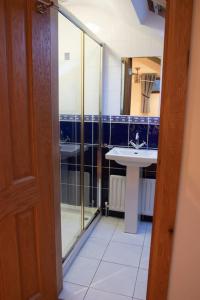 a bathroom with a glass shower and a sink at Spacious & Cosy fully equipped 4 bedroom house. in Dungiven