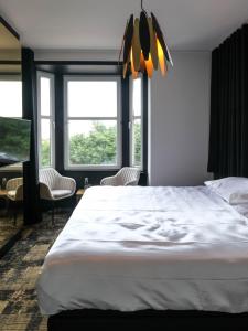 ミッデルケルケにあるBed & Breakfast Maison Noire Westende-bad incl parking & ontbijtの窓付きの客室で、白い大型ベッド1台が備わります。