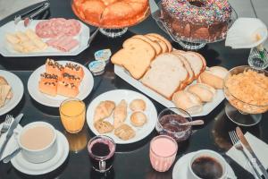 una mesa llena de diferentes tipos de pan y repostería en Pousada Tia Leonor, en Gramado