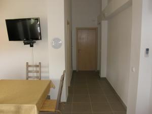 a hallway with a table and a television on a wall at Apartments Hrabric in Baška