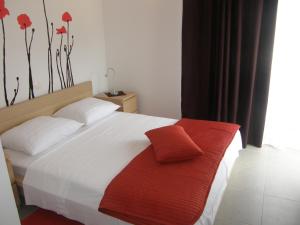 a bedroom with a white bed with a red towel on it at Apartments Hrabric in Baška