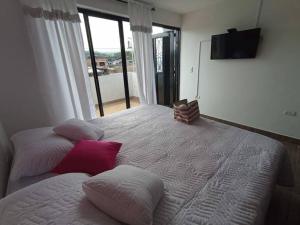 een slaapkamer met een groot bed met 2 kussens bij Cerca al centro con parqueo GRATIS - 2 habitaciones in Popayan