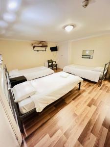 duas camas num quarto de hospital com pisos de madeira em Gresham Hotel Bloomsbury em Londres