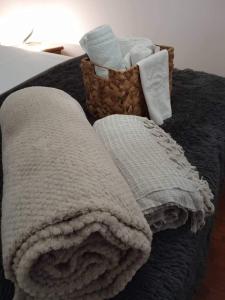 a blanket and a basket of towels on a bed at Adorable Cozy Apartment in Aglantzia
