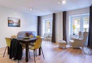 uma sala de estar com mesa e cadeiras em HITrental Zur Metzgern Apartments em Lucerna