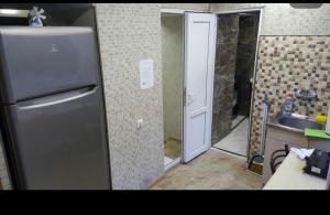 a small kitchen with a refrigerator and a sink at Ann Appartment in Tbilisi City