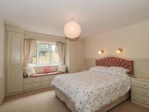 a bedroom with a large bed and a window at Rhode Acres in Sturminster Newton