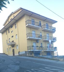 ファレルナにあるCasa giuseppeのバルコニーと通りを望む大きな黄色の建物