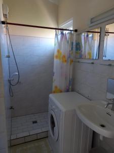 a bathroom with a washing machine and a sink at Seru Coral Resort studio 16 in Willemstad