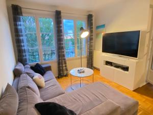 een woonkamer met een bank en een flatscreen-tv bij T5 Disney Paris/Val d’Europe in Serris