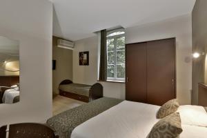 a hotel room with a bed and a window at Le Coligny in Brantôme