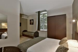 Una habitación de hotel con una cama y una ventana. en Le Coligny, en Brantôme