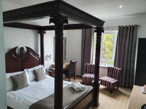 斯崔特的住宿－威塞克斯酒店，一间卧室配有四柱床和一张书桌