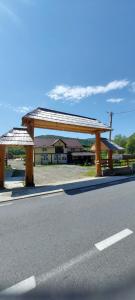 a wooden pavilion on the side of a road at La Ionicã Rozavlea MM in Rozavlea