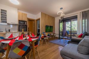 een keuken en een woonkamer met een tafel en stoelen bij Vila Pekovic Blue-Apartman PAMA in Zlatibor