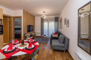 een woonkamer met een rode tafel en een bank bij Vila Pekovic Blue-Apartman PAMA in Zlatibor