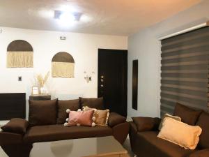 ein Wohnzimmer mit einem braunen Sofa und einem Tisch in der Unterkunft Gualdras Departments with parking 7min to downtown in Guanajuato