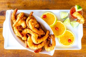 a white plate with calamari onion rings and orange slices at Pousada Recanto das Flores in Governador Celso Ramos