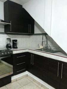 - une cuisine avec des placards noirs et un évier dans l'établissement Gualdras Departments with parking 7min to downtown, à Guanajuato