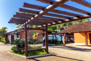 a wooden pergola in front of a building at Pousada Recanto das Flores in Governador Celso Ramos