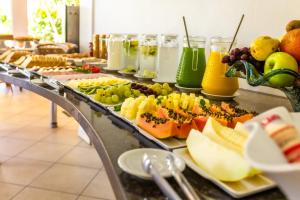 a buffet line with various fruits and juices at Pousada Recanto das Flores in Governador Celso Ramos