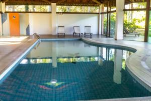 a swimming pool in a house with two chairs at Pousada Recanto das Flores in Governador Celso Ramos