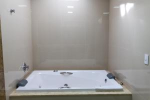 a bath tub with a sink in a bathroom at Pousada Recanto das Flores in Governador Celso Ramos