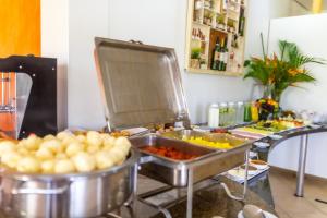 a buffet with plates of food on a table at Pousada Recanto das Flores in Governador Celso Ramos