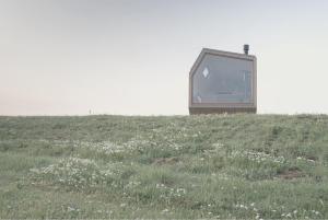 斯泰恩伯格tinyzeit Urlaub im tiny house an der Flensburger Förde的坐在草地上看电视