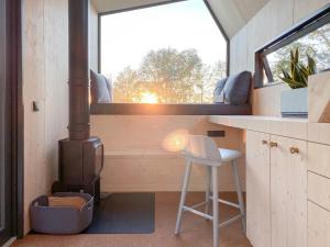 Cette petite maison dispose d'un poêle à bois et d'un tabouret. dans l'établissement tinyzeit Urlaub im tiny house an der Flensburger Förde, à Steinberg