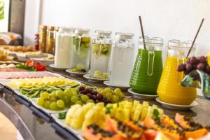 a buffet filled with different types of juice and fruit at Pousada Recanto das Flores in Governador Celso Ramos
