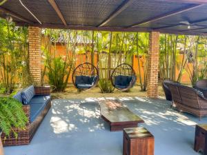a patio with wicker chairs and a wooden table at Pousada Recanto das Flores in Governador Celso Ramos