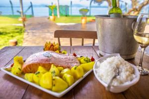 a plate of food with meat and vegetables on a table at Pousada Recanto das Flores in Governador Celso Ramos