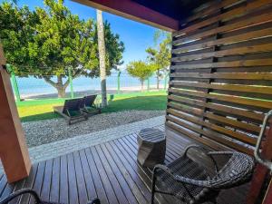 a wooden deck with two chairs and a swing at Pousada Recanto das Flores in Governador Celso Ramos