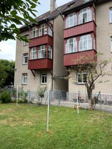 Un edificio con una valla roja delante. en Wohlfühl Loft - Seenähe, Boxspringbett, Küche, en Bregenz