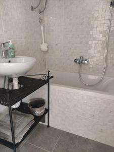 a bathroom with a sink and a shower and a tub at Apartman Ela in Banja Luka