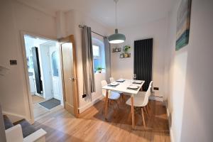 a dining room with a white table and chairs at The Coffee Pot Cottage in Town Centre FREE Parking in Stratford-upon-Avon