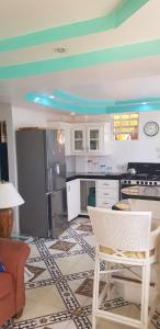 cocina con armarios blancos y techo azul en Casa De Amor Suites and Tours 