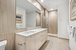 a bathroom with a sink and a toilet and a mirror at Global Luxury Suites at Reston Town Center in Reston