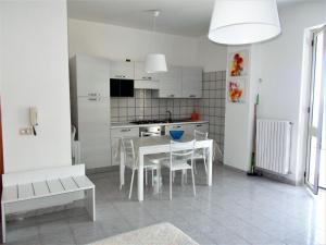 una cucina bianca con tavolo e sedie in una stanza di Donna Ester - Discover Cilento a Pisciotta