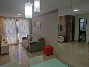 uma sala de estar com uma cama e um banco vermelho em Apartamento Blue Tower em Maceió