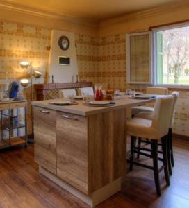 uma cozinha com uma ilha com cadeiras e um relógio na parede em Casa santoni 20 em Grosseto-Prugna