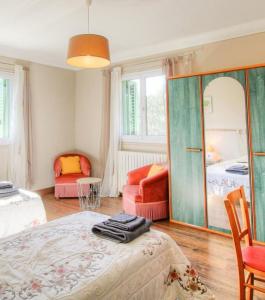 a bedroom with a bed and a mirror and two chairs at Casa santoni 20 in Grosseto-Prugna