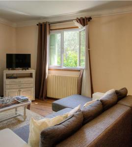 uma sala de estar com um sofá e uma janela em Casa santoni 20 em Grosseto-Prugna