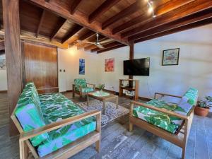 a living room with two beds and a flat screen tv at Luxury Villa Panorama Verde Pool House in Punta Uva