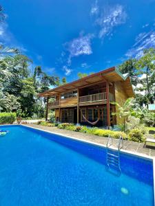 a house with a swimming pool in front of a house at Luxury Villa Panorama Verde Pool House in Punta Uva